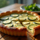 Tarte courgette et chèvre fraîche servie sur une table en bois